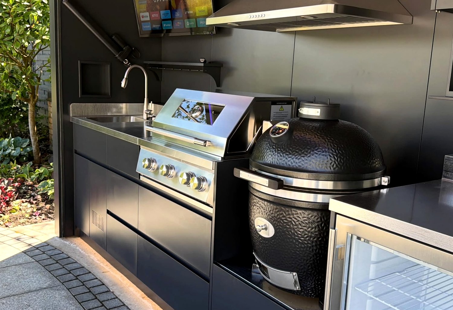 Lift-up outdoor kitchen interior with grill, sink and appliance layout