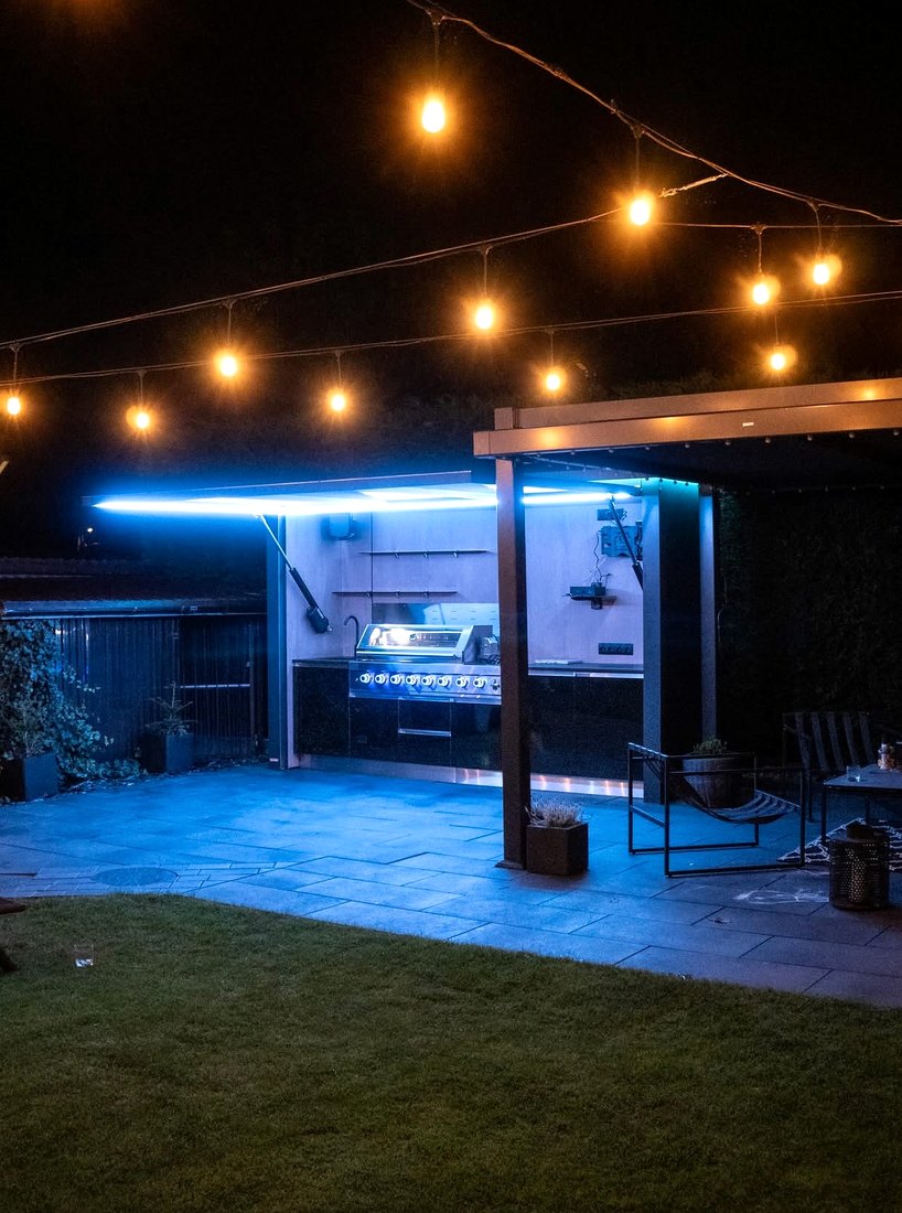 Lift-up outdoor kitchen at night with blue lighting