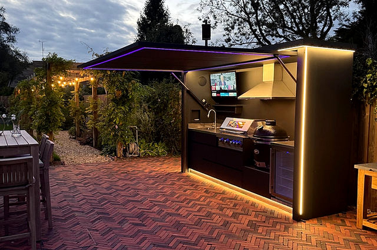 Lift-up outdoor kitchen night installation with warm lighting