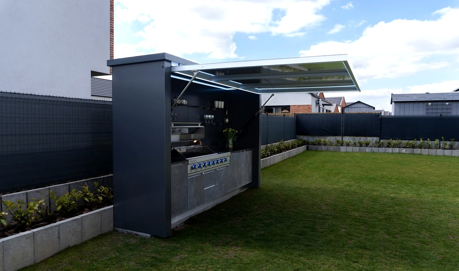 Lift-up outdoor kitchen side structure installed beside a garden