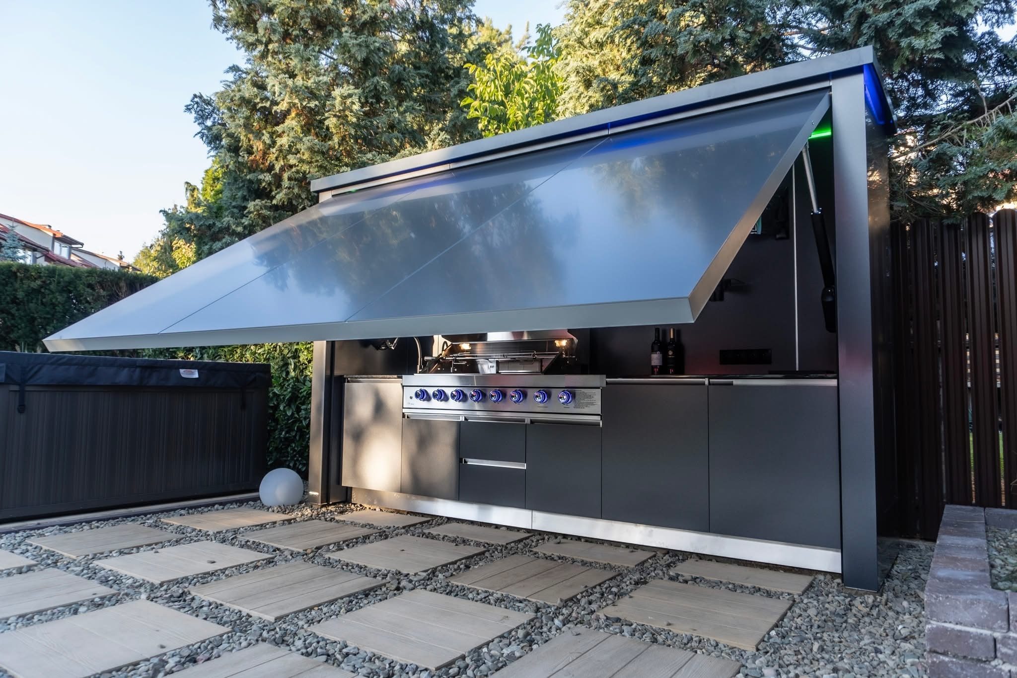 Luxury outdoor kitchen module open in a landscaped residential garden