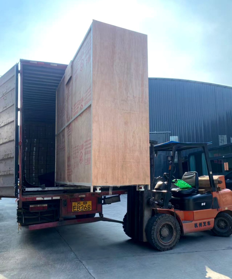 Wooden case packed outdoor kitchen module being loaded into a container by forklift